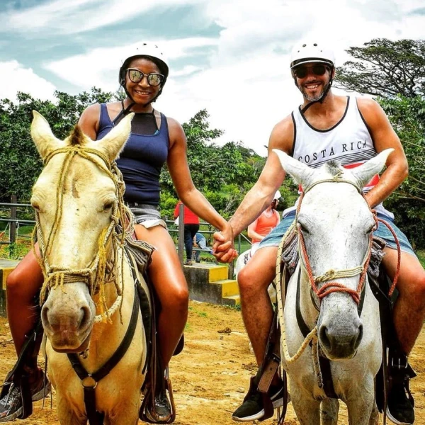 Tamika and Logan in Costa Rica on horses holding hands