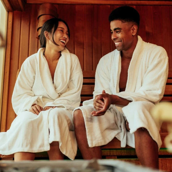 a couple in a sauna in robes